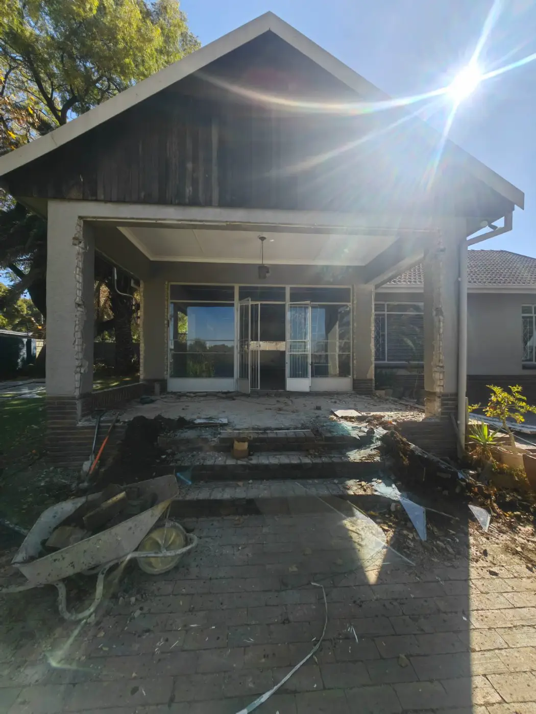 Before: the old porch with white steel doors, rubble and a wheelbarrow