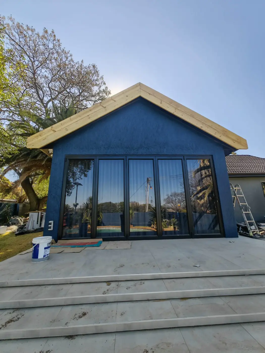 After: the finished gable with black-framed folding glass doors